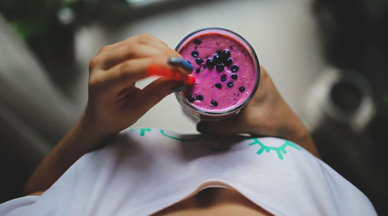 Girl holding a pink smoothie